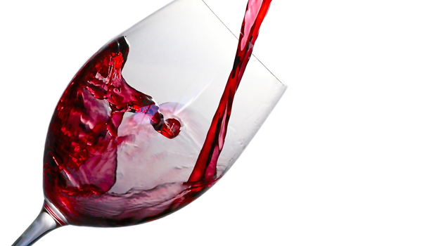 a wine glass with wine being poured